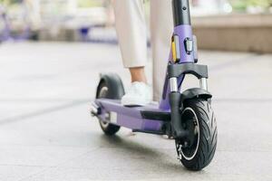 Close up of young woman riding on electric scooter in city. photo