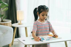 cute little asian child girl using colorful plasticine at home photo