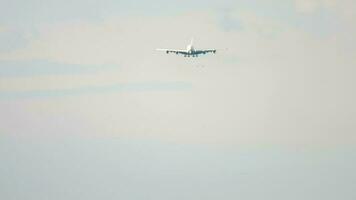 Widebody aircraft approaching landing, long shot. Airplane descending, view through haze. Tourism and aviation concept video