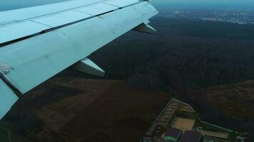 View from the plane window, POV on the evening city. Plane landing video