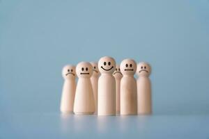 Group of wooden human figures standing in community society concept. Wooden dolls on light blue background. photo