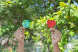 Hands holding earth paper and water paint. Concept of protecting the world from global warming. Sustainability topic to save the world. photo