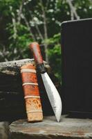 E-nep knife Thai native Knives for survival in the forest on an old timber wooden photo