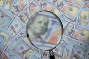 Blurred image of us dollar bill through magnifying lens checking banknotes photo