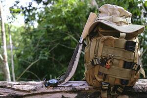 Knife backpack with equipment for survival in the forest on an old timber wooden photo