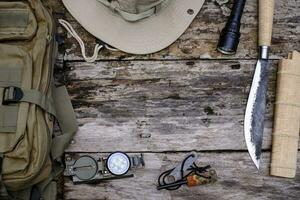 Knife backpack with equipment for survival in the forest on the old wooden background photo