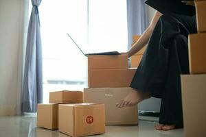 woman checking package of goods from customer online order is alone in her home office as she is an SME entrepreneur and uses her phone and tablet to market online. concept online sales business photo