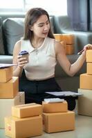 small sme entrepreneur is packing products into parcel boxes in preparation for transporting them to freight forwarder to deliver to customers with incoming orders. Concept Ecommerce Team online sales photo