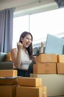 woman checking package of goods from customer online order is alone in her home office as she is an SME entrepreneur and uses her phone and tablet to market online. concept online sales business photo