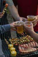 Beer drinks prepared for barbecue party among friends are served in plastic glasses because plastic glasses can be easily stored at end of party. Easy party idea by serving beer in plastic glasses. photo