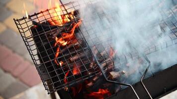 Empty flaming charcoal grill with open fire, ready for product placement. Concept of summer grilling, barbecue, bbq and party. Selective focus. Close-up top view video