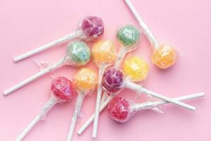 Sweet lollipops on pink background photo