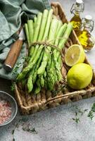 Bunch of raw asparagus stems with different spices photo