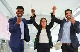 group of young business people clasping hands and raising, the signal of teamwork with happily photo