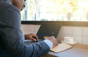 african american businessman writing business plan while working at counter bar in cafe indoor ,selective focus photo