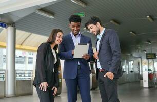 business inspectors using tablet and talking about business together in front of skytrain fare gates photo