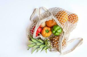 concept of lifestyle eco friendly bag keep zero waste, string shopping bag full of fruits and vegetables isolated on white background photo