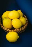 Basket with ripe lemons. On a rustic blue dark background. High quality photo