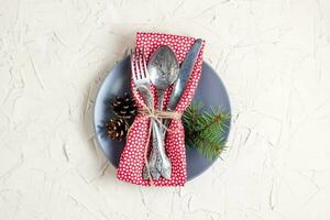 Christmas menu background with fork knife napkin and fir tree brunch on white table. Copy space, top view photo