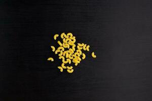 A pile of pasta horns on black background photo