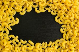 Frame of A pile of pasta horns on black background with copyspace photo