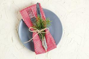 Christmas menu background with fork knife napkin and fir tree brunch on white table. Copy space, top view photo