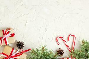 Christmas or New Year decorations background with pine cones, fir branches, gift boxes, and candy canes photo