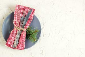 Christmas menu background with fork knife napkin and fir tree brunch on white table. Copy space, top view photo
