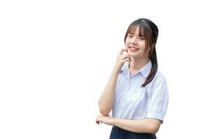 linda alto colegio asiático estudiante niña en el colegio uniforme soportes y sonrisas felizmente mientras con confianza mientras aislado en blanco antecedentes. foto