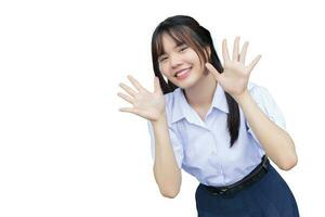 bonito asiático alto colegio estudiante niña en el colegio uniforme con sonrisas con confianza mientras ella mira a el cámara felizmente mientras aislado en blanco antecedentes. foto