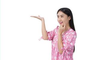 Asian beautiful young woman with black long hair in pink shirt shows present something isolated on white background. photo