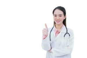 Professional young Asian woman doctor who wears medical coat shows thump up as good sign in health protection concept in health care concept isolated on white background. photo