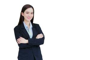 profesional confidente asiático trabajando mujer quien tiene largo pelo usa negro formal traje con azul camisa mientras ella brazo cruce y sonriente felizmente aislado en blanco antecedentes. foto