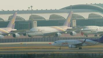 BANGKOK, THAILAND JANUARY 21, 2023 - Airbus A320, HS TXF of Thai Smile taxiing at Suvarnabhumi Airport, Bangkok. Row of planes docked to the terminal. View of the airfield of a modern airport video