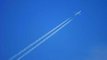 Airplane flying in a blue sky with a contrail video