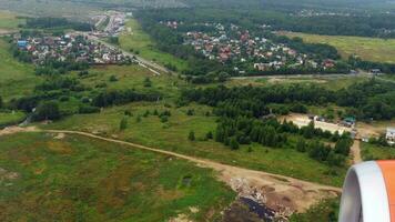 The plane descends for a landing in Moscow, view from the window. Summer, green forests and fields, view from the airplane window video