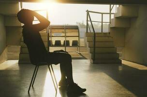 Silhouetted of sad photo. Lonely man sitting on the floor.He is unhappy and sad.He is depression.unlove,unhappy,fail.Photo concept for Disease and depression. photo