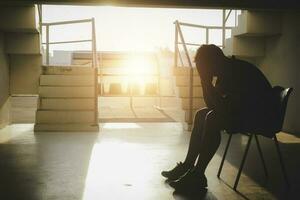 Silhouetted of sad photo. Lonely man sitting on the floor.He is unhappy and sad.He is depression.unlove,unhappy,fail.Photo concept for Disease and depression. photo