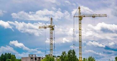 tempo periodo di Due Torre gru Lavorando su costruzione con tempesta soffice Riccio rotolamento nuvole come sfondo video