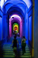 Bologna,Italy- June 23, 2023-People stroll at night under the arcades leading to the sanctuary of San Luca illuminated for the first edition of the Bologna arcades Festival. photo