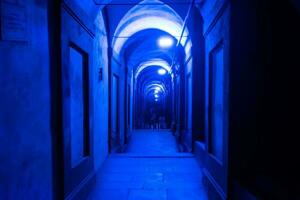 Bologna,Italy- June 23, 2023-People stroll at night under the arcades leading to the sanctuary of San Luca illuminated for the first edition of the Bologna arcades Festival. photo