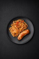 Delicious juicy grilled sausage with pasta or noodles with salt, spices and herbs photo