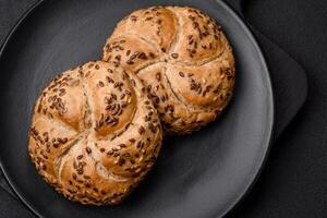 Delicious freshly baked crispy bun or kaiser roll with sesame seeds photo