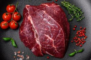 Fresh raw beef steak with salt, spices and herbs photo