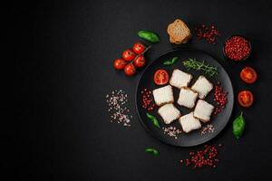 Delicious salty rectangular wheat croutons with cream cheese and tomatoes photo