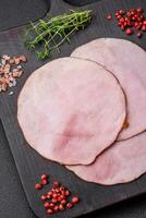 Delicious fresh ham cut into round slices with salt, spices and herbs photo