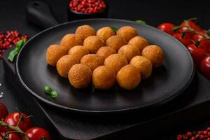 Delicious fried potato balls with breaded mozzarella, salt, spices and herbs photo