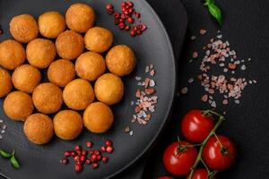 Delicious fried potato balls with breaded mozzarella, salt, spices and herbs photo