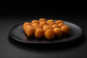 Delicious fried potato balls with breaded mozzarella, salt, spices and herbs photo