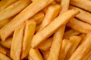 Delicious crispy french fries with salt and spices in a cardboard box photo